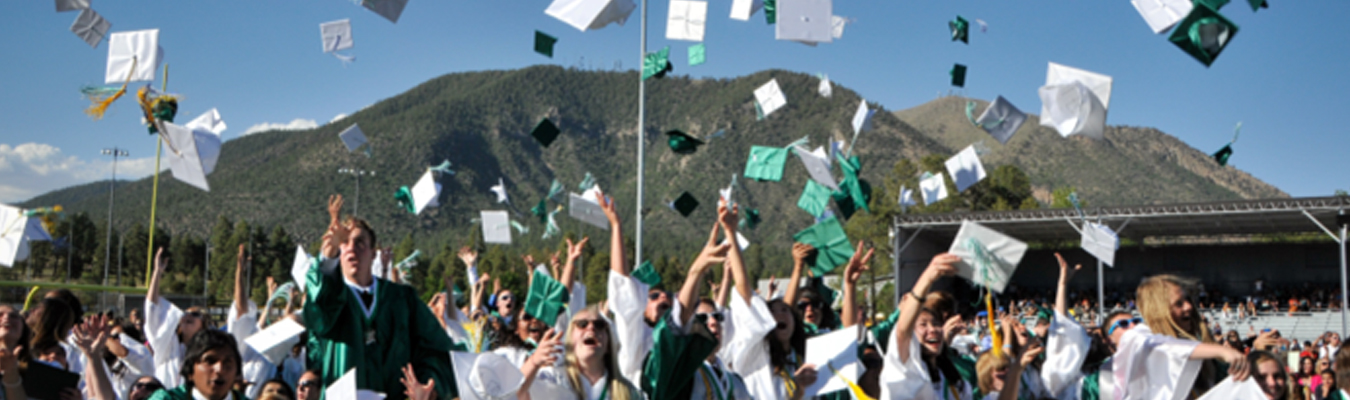 Flagstaff graduates tossing caps in air Mt Elden background LAUNCH Flagstaff