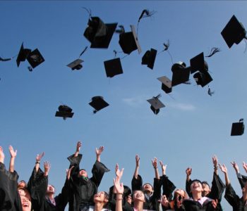 Graduates tossing caps in the air