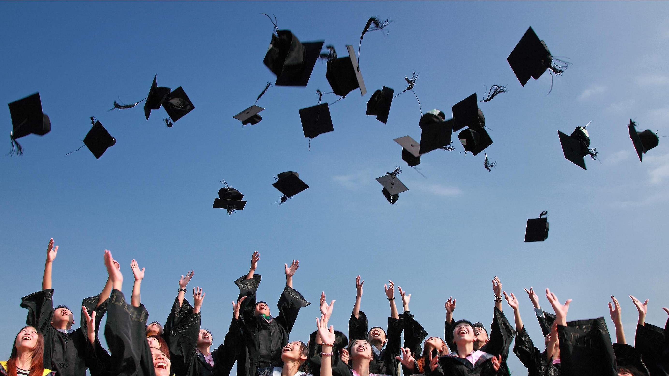 Graduates tossing caps in the air